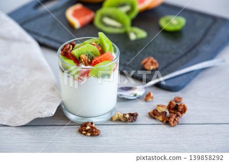 healthy yogurt with kiwi grapefruit and walnuts in glass healthy yogurt with kiwi grapefruit and walnuts in glass 139858292