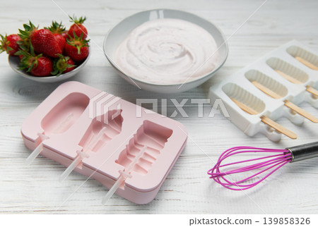 Preparing homemade strawberry ice cream popsicles Preparing homemade strawberry ice cream popsicles 139858326