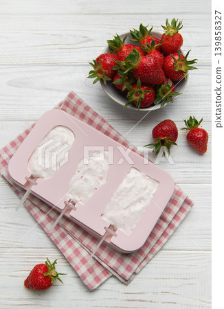 Making homemade strawberry ice cream popsicles in silicone mold Making homemade strawberry ice cream popsicles in silicone mold 139858327
