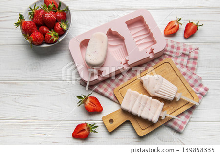 Homemade strawberry yogurt popsicles on white wooden table Homemade strawberry yogurt popsicles on white wooden table 139858335