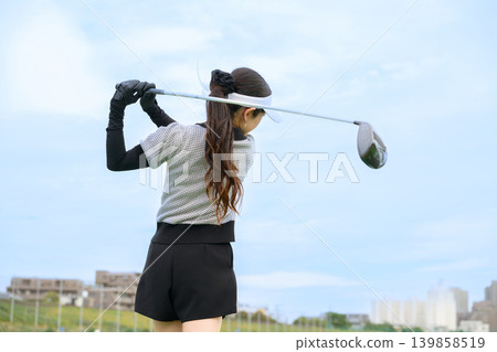 Japanese woman swinging a golf club 139858519