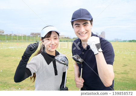 一對男女在練習高爾夫時面帶微笑。 一對男女在練習高爾夫時面帶微笑。 139858572