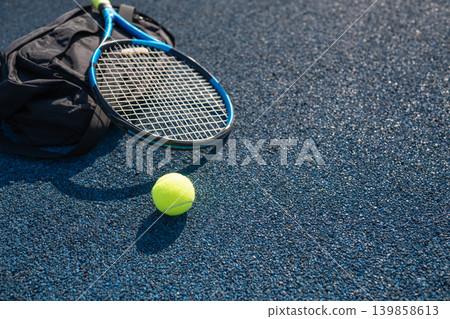 Tennis racket bag and ball on outdoor hard court with copy space Tennis racket bag and ball on outdoor hard court with copy space 139858613