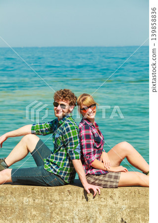 hiking couple relaxing on sea coast hiking couple relaxing on sea coast 139858836