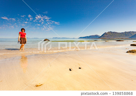 Woman walking on sandy beach, Lofoten Norway Woman walking on sandy beach, Lofoten Norway 139858868