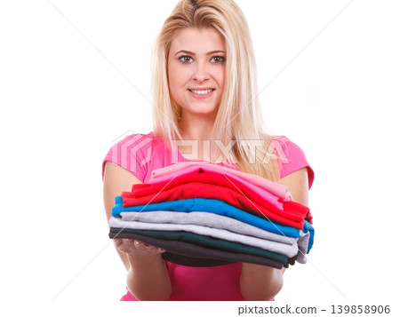 Woman holding pile of folded clothes Woman holding pile of folded clothes 139858906