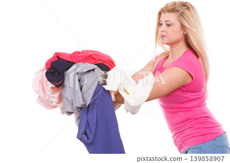 Woman holding pile of creased clothes 139858907