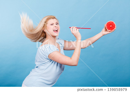 Woman drinking juice from fruit, red grapefruit 139858979