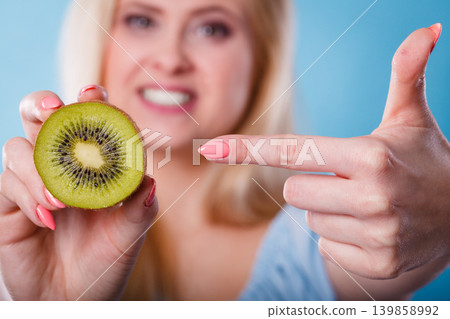 Woman holding green kiwi fruit Woman holding green kiwi fruit 139858992