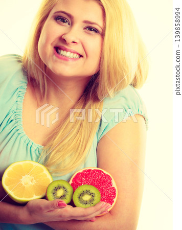 Woman holding fruits kiwi. orange, lemon and grapefruit Woman holding fruits kiwi. orange, lemon and grapefruit 139858994