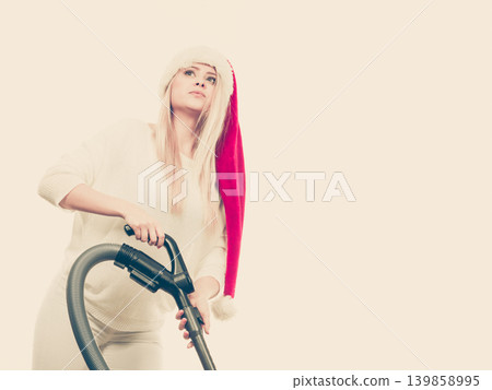 Girl in santa helper hat with vacuum cleaner 139858995
