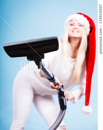 Girl in santa helper hat with vacuum cleaner 139858997