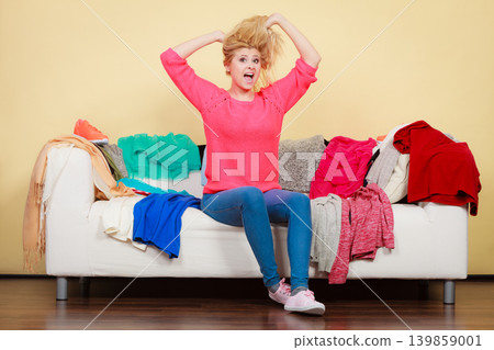 Woman does not know what to wear sitting on couch 139859001