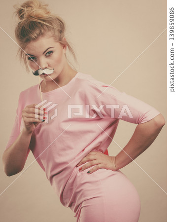 Happy woman holding fake moustache on stick 139859086