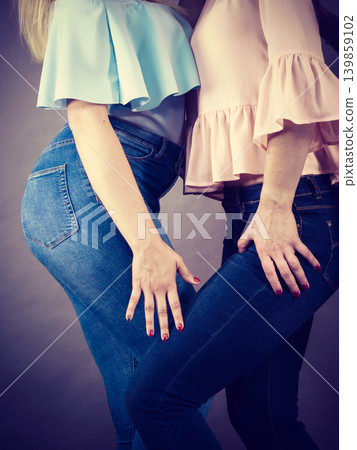 Unrecognizable women presenting jeans Unrecognizable women presenting jeans 139859102
