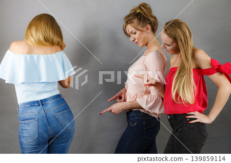 Women gossiping about friend body shape 139859114