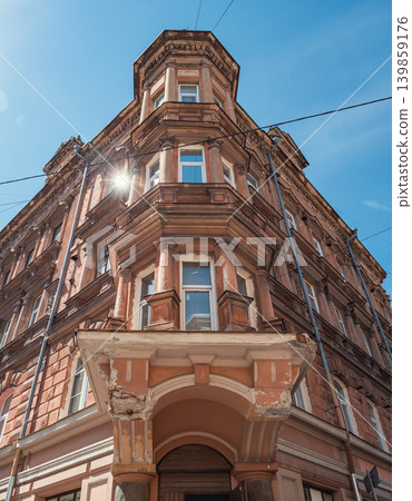 Old city building corner with ornate architecture and decorative columns brightly lit by sun at daytime 139859176