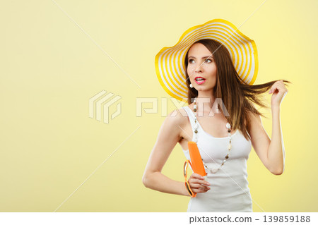 Woman in summer hat holds sunglasses sunscreen lotion Woman in summer hat holds sunglasses sunscreen lotion 139859188