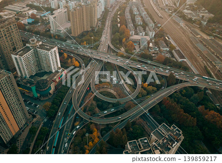 Aerial perspective captures a bustling multilevel highway interchange with cars moving across various elevated lanes in a vibrant Chinese city Aerial perspective captures a bustling multilevel highway interchange with cars moving across various elevated lanes in a vibrant Chinese city 139859217