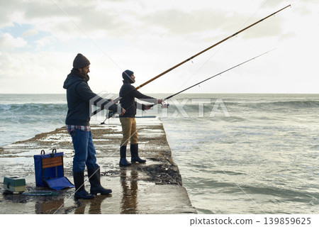 Fishing, friends and travel with men at beach for adventure, holiday and hobby break. Sunset, calm and patience with male fisherman and casting rod pole in nature for recreation, view and vacation Fishing, friends and travel with men at beach for adventure, holiday and hobby break. Sunset, calm and patience with male fisherman and casting rod pole in nature for recreation, view and vacation 139859625