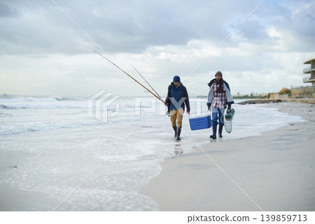 Water, fishing and men walking on beach together with cooler, tackle box and holiday conversation. Ocean, fisherman and friends with rods, bait and tools at waves on winter morning vacation at sea. Water, fishing and men walking on beach together with cooler, tackle box and holiday conversation. Ocean, fisherman and friends with rods, bait and tools at waves on winter morning vacation at sea. 139859713