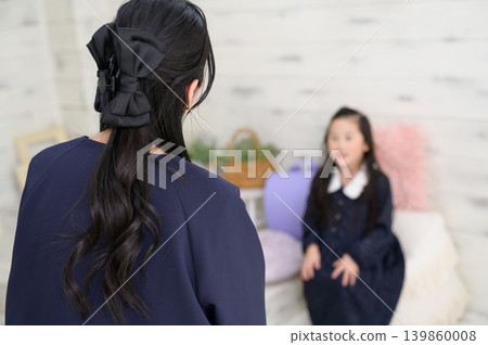 A Japanese girl practicing for her entrance exam with her mother. A Japanese girl practicing for her entrance exam with her mother. 139860008