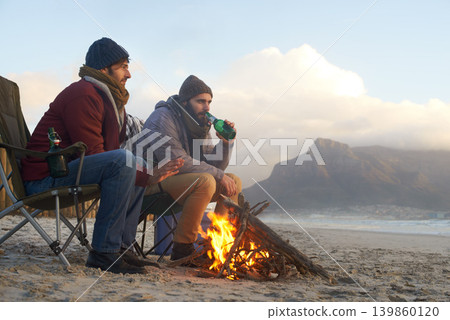 Campfire, friends and beer with men by the beach at sunset with vacation and camping. Ocean, outdoor and together with travel and people in a trip and journey with fire and alcohol by sea at dawn 139860120
