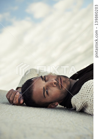 Fashion, sand or portrait of man in the desert for travel in summer to relax on holiday vacation. Wellness, male person or face of model on outdoor adventure with confidence or cool style in nature Fashion, sand or portrait of man in the desert for travel in summer to relax on holiday vacation. Wellness, male person or face of model on outdoor adventure with confidence or cool style in nature 139860203
