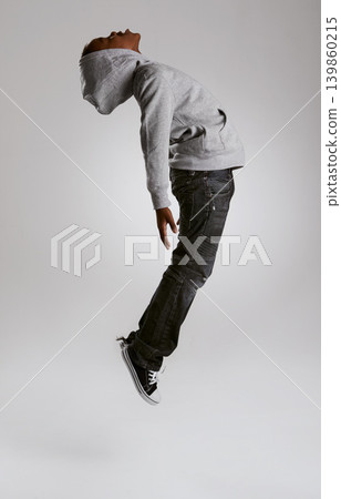 Teen, fashion and jump with energy in studio with kid in streetwear hoodie on grey background. African, child and cool boy in the air with casual style, clothes and comfortable outfit in mockup Teen, fashion and jump with energy in studio with kid in streetwear hoodie on grey background. African, child and cool boy in the air with casual style, clothes and comfortable outfit in mockup 139860215