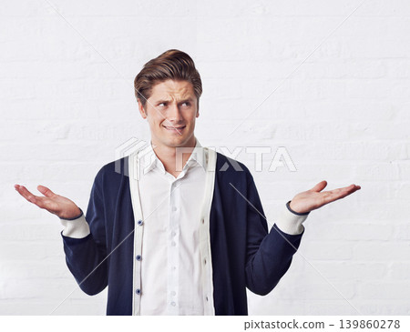 Confused, thinking and man with doubt on a white background for choice, option and decision. Facial expression, reaction and isolated person with unsure, question and wonder shrug gesture in studio Confused, thinking and man with doubt on a white background for choice, option and decision. Facial expression, reaction and isolated person with unsure, question and wonder shrug gesture in studio 139860278