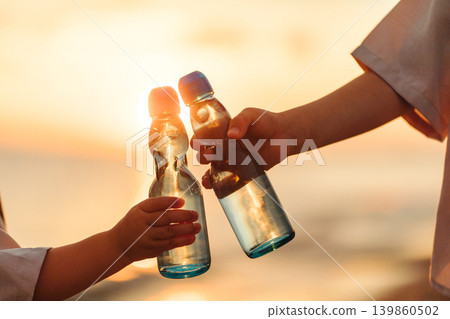 Toasting with lemonade on the beach at sunset Toasting with lemonade on the beach at sunset 139860502