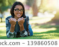 Happy woman, student and relax with book in nature for literature, studying or story on green grass. Young nerd, geek or female person with smile and glasses for chapter, learning or outdoor reading 139860508