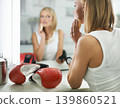 Female person, bruise and boxing gloves by mirror, makeup and stylish outfit in dressing room. Woman, blush and eyeshadow for sport match, reflection and fashion to prepare for post interview 139860521