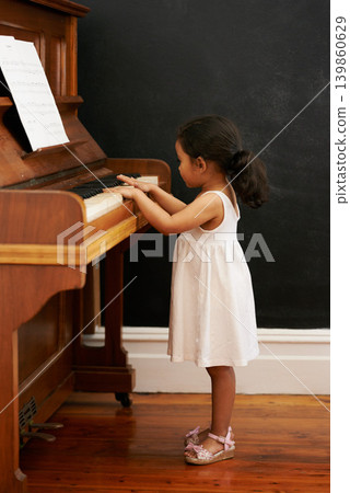 Piano, girl and toddler in home for learning, practice and classical education with musical notes. Training, melody and kid with talent, creative or hobby with instrument, child development or skill Piano, girl and toddler in home for learning, practice and classical education with musical notes. Training, melody and kid with talent, creative or hobby with instrument, child development or skill 139860629