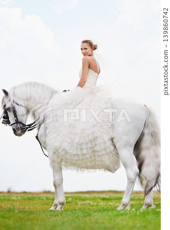 Wedding, woman and portrait with riding horse or happy for celebration, marriage and confidence in countryside. Bride, person and stallion on lawn in field with smile, dress and animal at ceremony Wedding, woman and portrait with riding horse or happy for celebration, marriage and confidence in countryside. Bride, person and stallion on lawn in field with smile, dress and animal at ceremony 139860742