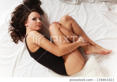 Sad girl lonely woman lying on bed in bedroom Sad girl lonely woman lying on bed in bedroom 139861021