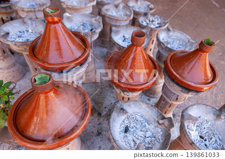 Handmade clay tajine cookware in Moroccan cuisine preparation Handmade clay tajine cookware in Moroccan cuisine preparation 139861033