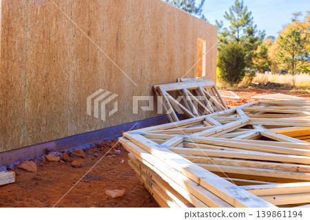 Wooden beams frames lay to wall at construction site in countryside Wooden beams frames lay to wall at construction site in countryside 139861194