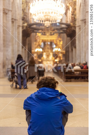 Tourist meditating inside Santiago de Compostela Cathedral Tourist meditating inside Santiago de Compostela Cathedral 139861456