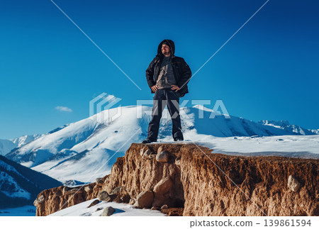 Young smiling man tourist standing on mountain at winter season Young smiling man tourist standing on mountain at winter season 139861594