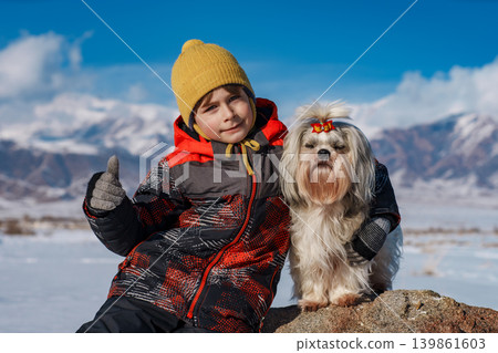 Child with shih tzu dog winter portrait on mountains background 139861603