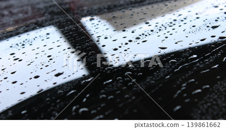 Drops of water dissolve the liquid wax coating on the glass surface 139861662