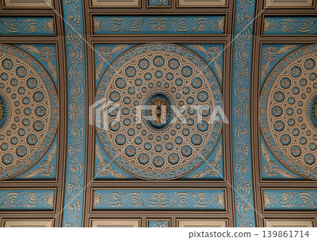 an ornately decorated, neoclassical ceiling painted in a striking palette of powder blue and cream, featuring an intricate central medallion composed of concentric geometric patterns and gilded floral an ornately decorated, neoclassical ceiling painted in a striking palette of powder blue and cream, featuring an intricate central medallion composed of concentric geometric patterns and gilded floral 139861714