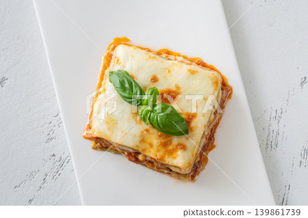 Classic Lasagna Bolognese Slice With Golden Mozzarella And Fresh Basil Garnish 139861739