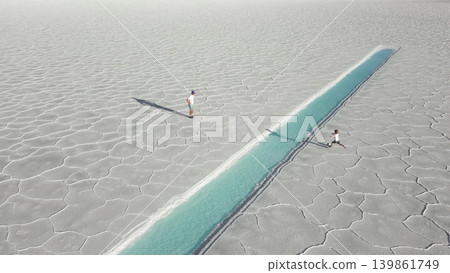 Aerial view of father and child playing soccer onwhite salt flats Salinas Jujuy Argentina Aerial view of father and child playing soccer onwhite salt flats Salinas Jujuy Argentina 139861749