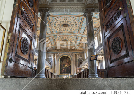the majestic interior of the chapel opens into a breathtaking vista of neoclassical grandeur. Stately fluted columns frame the central nave, guiding the eye toward an illuminated altar painting while 139861753
