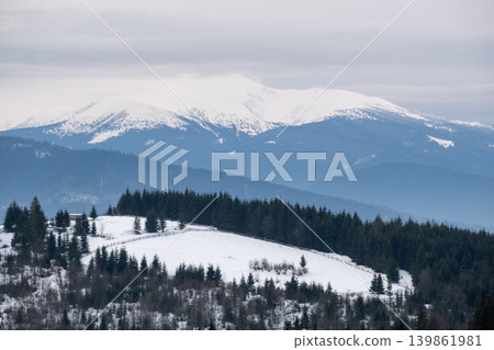 Winter evening overcast twilight mountains (Ukraine, Carpathians - Hoverla mountain peak scenery view from Yablunytsia Pass). Winter evening overcast twilight mountains (Ukraine, Carpathians - Hoverla mountain peak scenery view from Yablunytsia Pass). 139861981