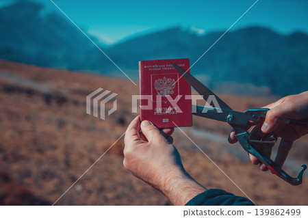 Man cutting Russian passport on mountains background, immigration concept 139862499
