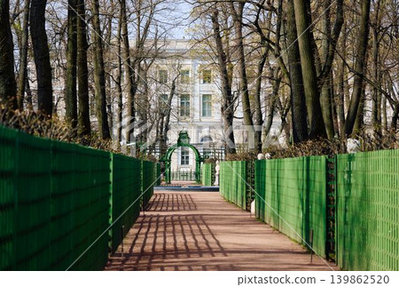 people stroll through the summer garden on a sunny May morning, Russia, St.Petersburg, alleys of trees and statues, the Fontanka River embankment with a view of the engineering castle people stroll through the summer garden on a sunny May morning, Russia, St.Petersburg, alleys of trees and statues, the Fontanka River embankment with a view of the engineering castle 139862520