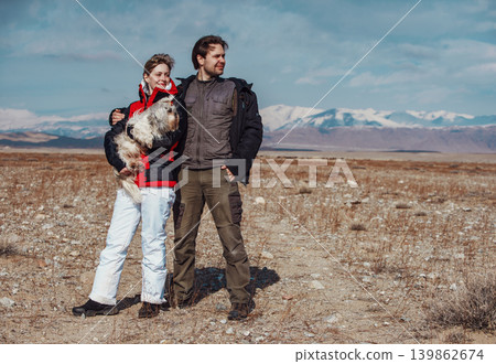 Man and woman with shih tzu dog standing on mountains background at winter season 139862674